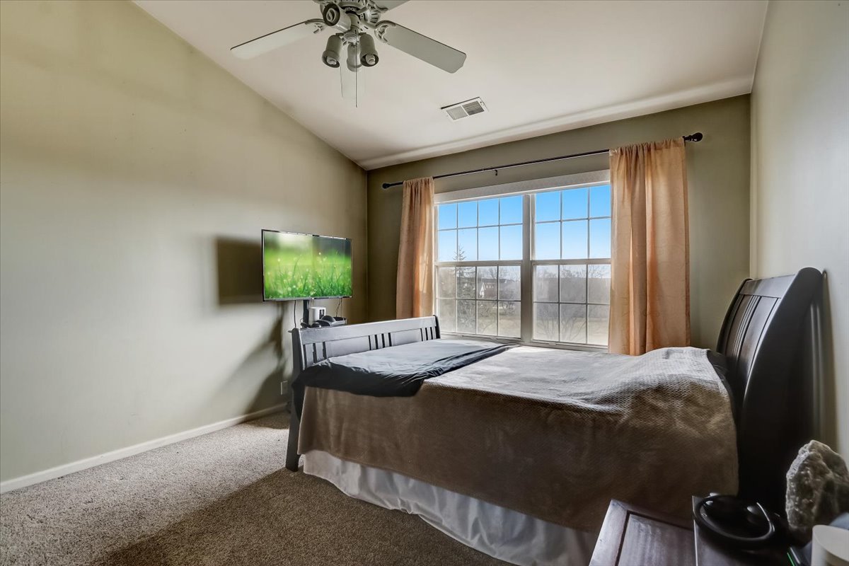 17885 Braewick Road, Unit 17217 Gurnee, IL 60031 - Photo 21 of 35 a bedroom with a bed and a chandelier