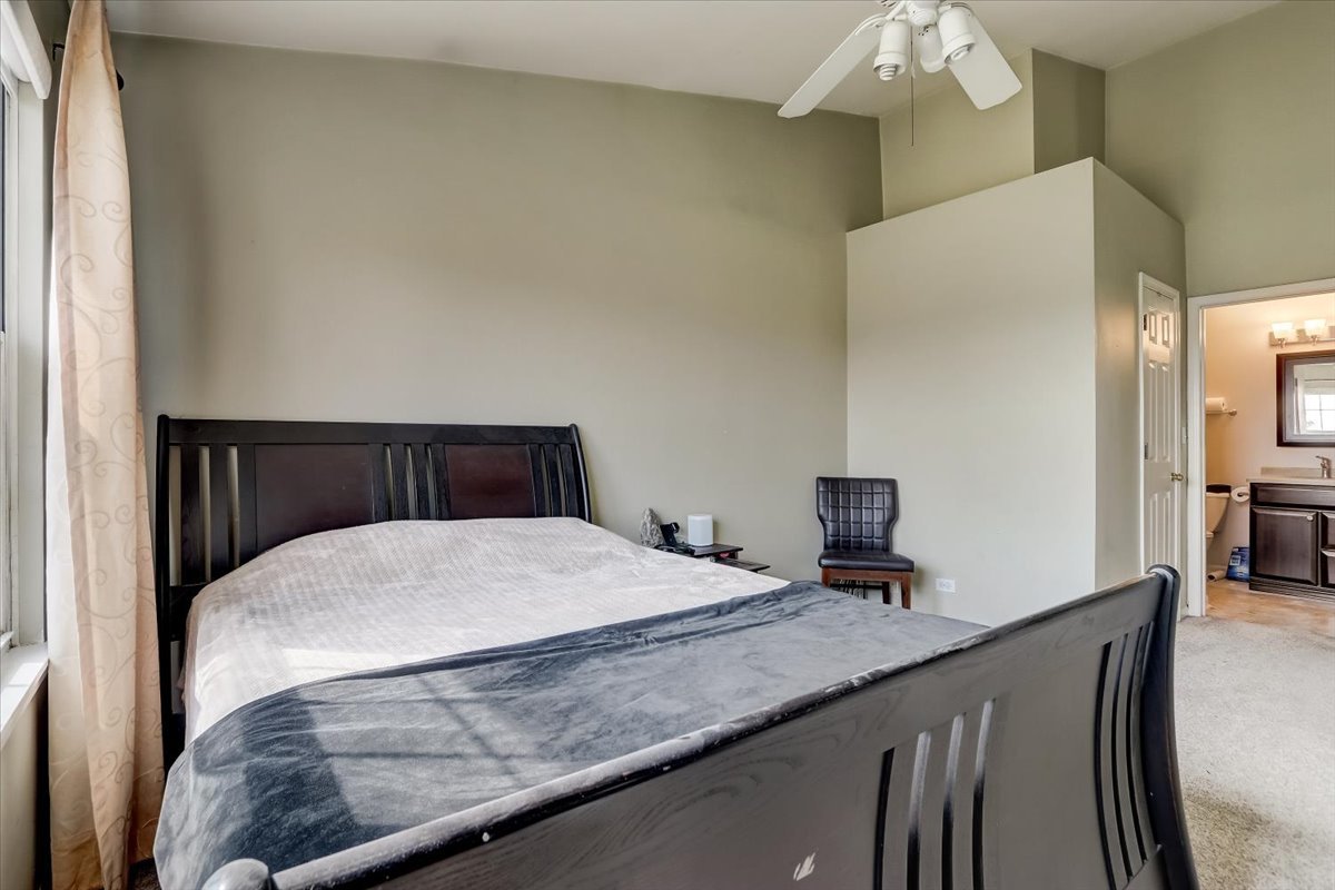 17885 Braewick Road, Unit 17217 Gurnee, IL 60031 - Photo 22 of 35 a bedroom with a bed and a chandelier