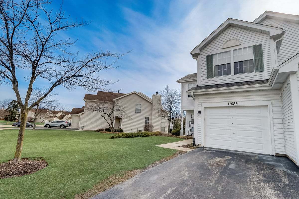 17885 Braewick Road, Unit 17217 Gurnee, IL 60031 - Photo 3 of 35 a view of a white house that has a tree in front of it