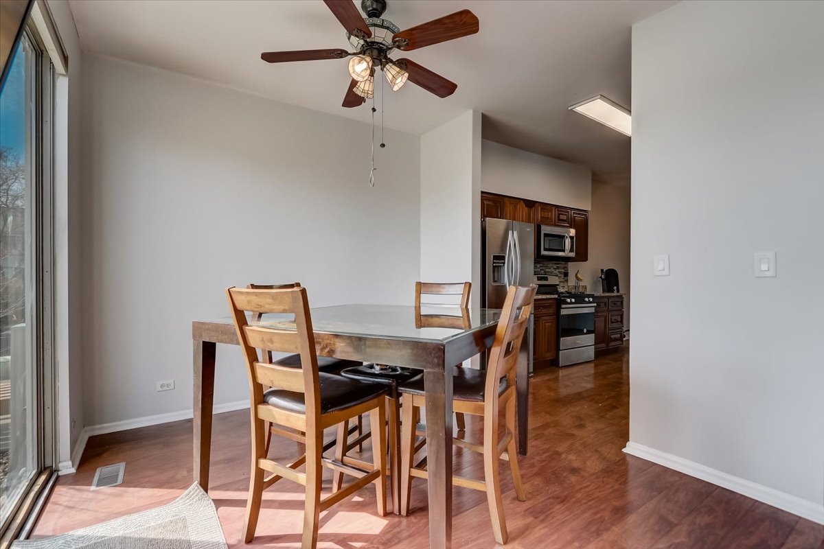 17885 Braewick Road, Unit 17217 Gurnee, IL 60031 - Photo 9 of 35 a view of a dining room with furniture and a chandelier fan