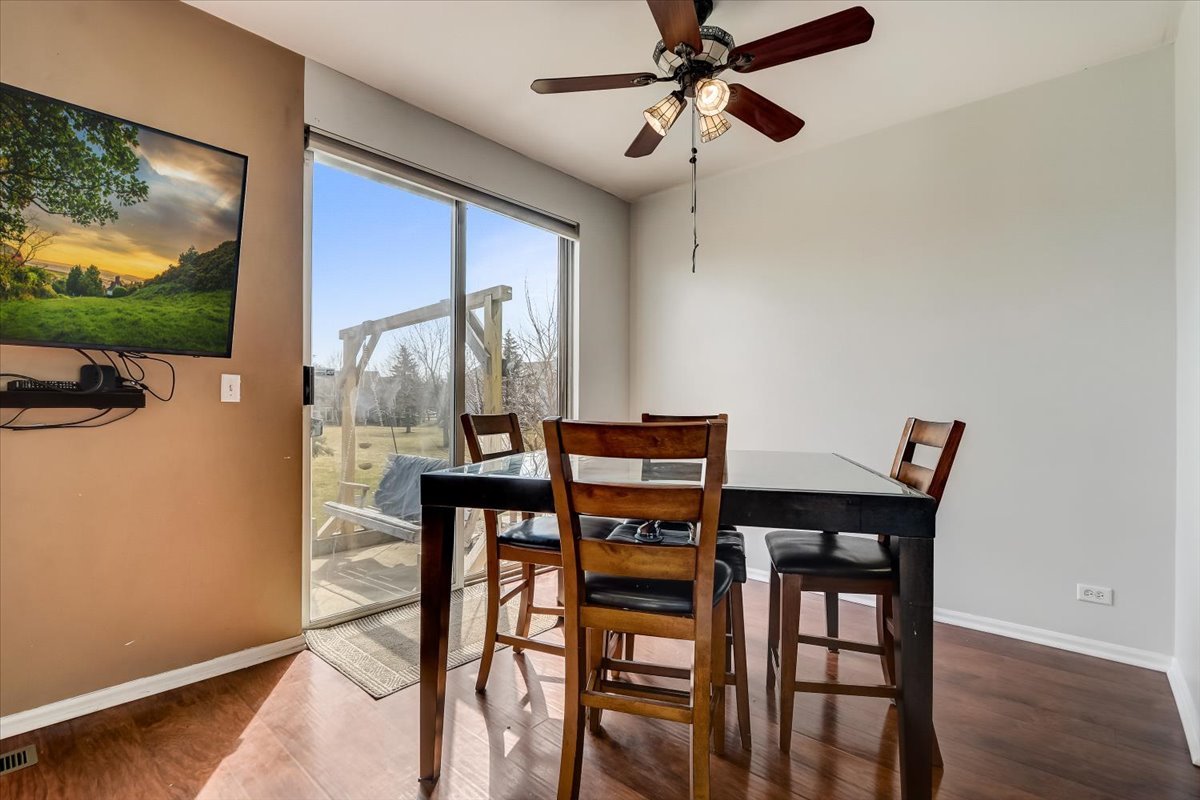 17885 Braewick Road, Unit 17217 Gurnee, IL 60031 - Photo 10 of 35 a view of a dining room with furniture window and wooden floor