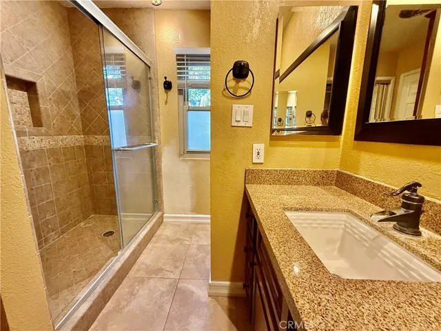 a bathroom with a granite countertop sink and a mirror
