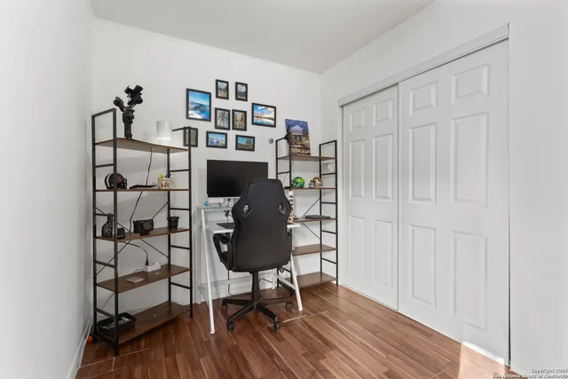a view of a workspace with furniture and wooden floor