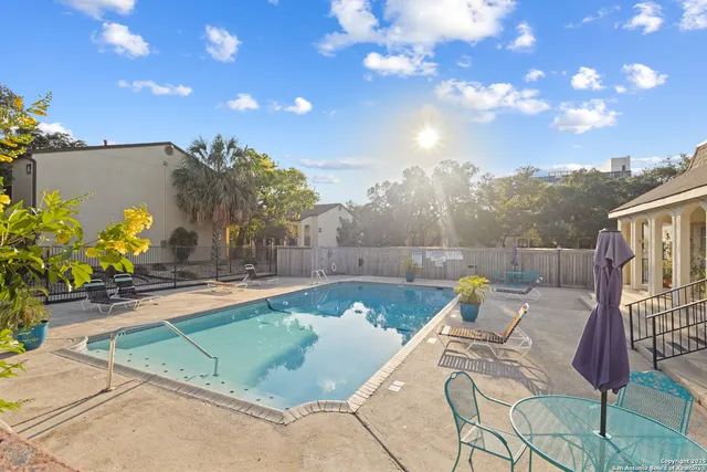 a view of a swimming pool with a patio and a fire pit