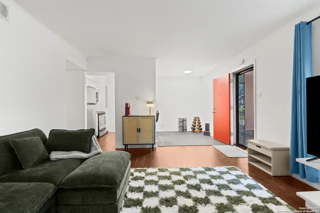a living room with a couch and a dresser with wooden floor