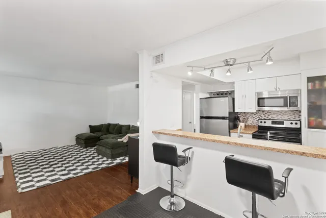 a kitchen with stainless steel appliances kitchen island granite countertop a sink and cabinets