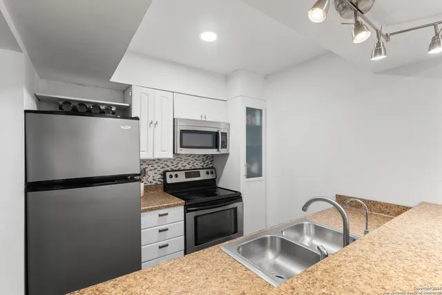a kitchen with refrigerator a stove and a sink