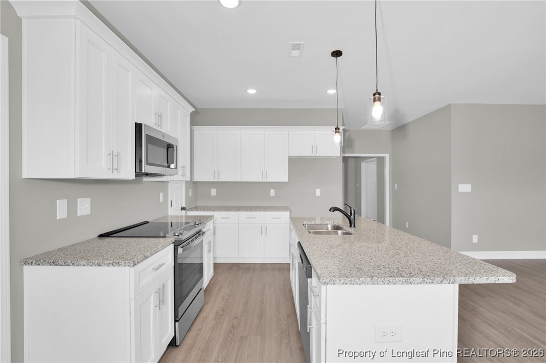 307 Barberry Road Raeford, NC 28376 - Photo 21 of 38 a kitchen with a sink a stove a refrigerator and white cabinets