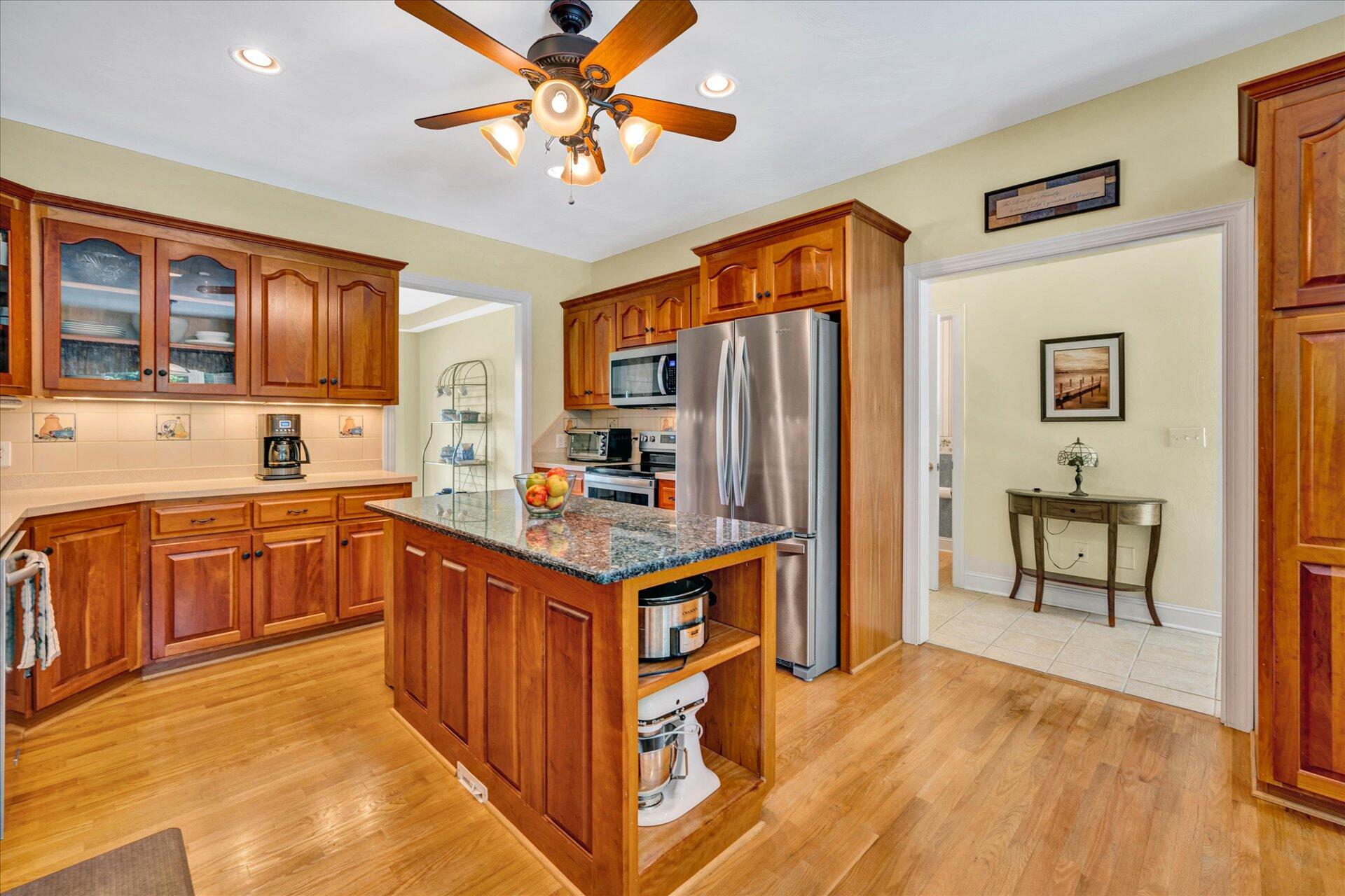 325 Rock Ridge Road Callaway, VA 24067 - Photo 16 of 74 a kitchen with stainless steel appliances granite countertop a refrigerator a sink dishwasher a stove with wooden cabinets and floor