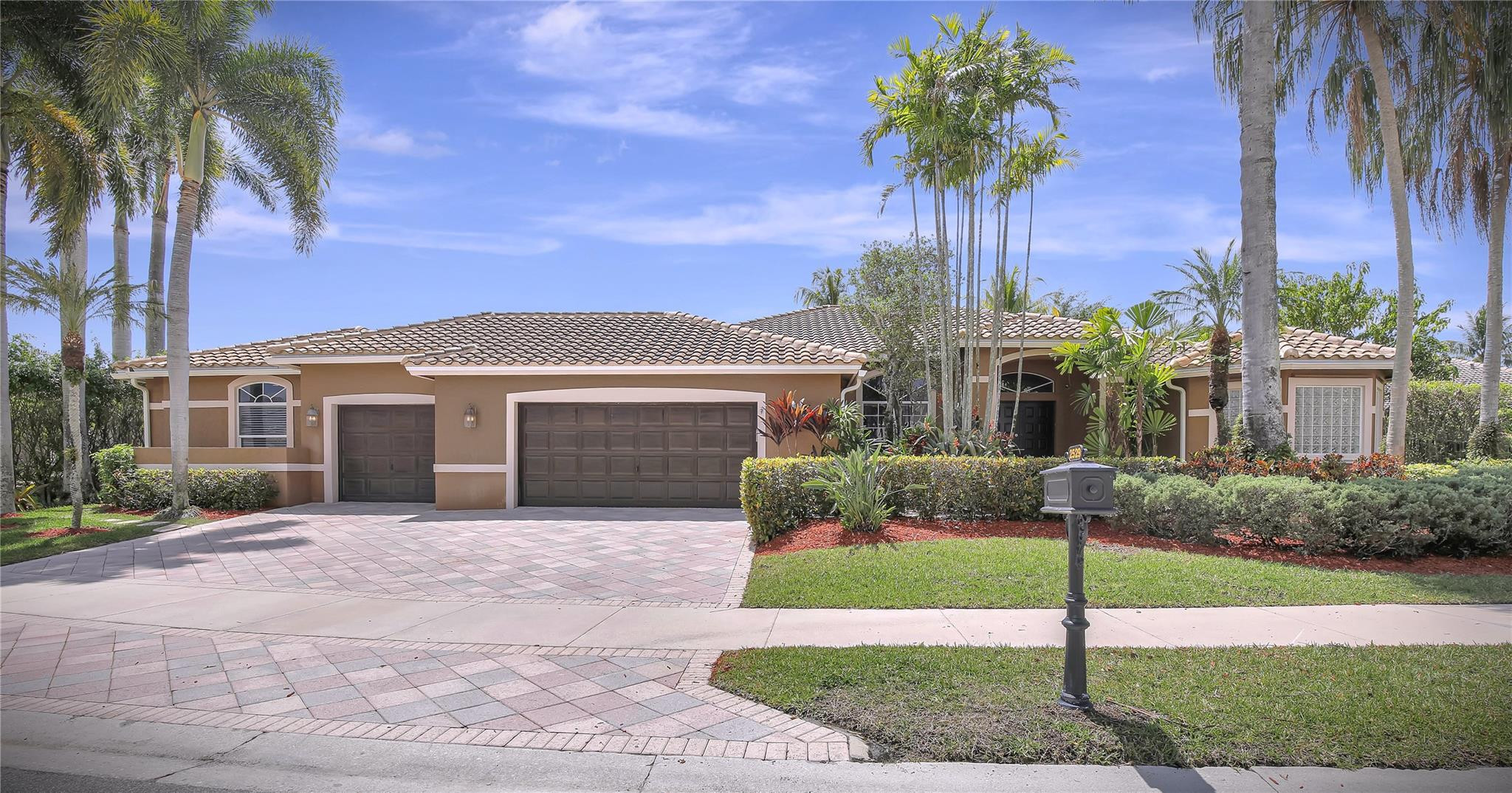 a front view of a house with a garden and yard
