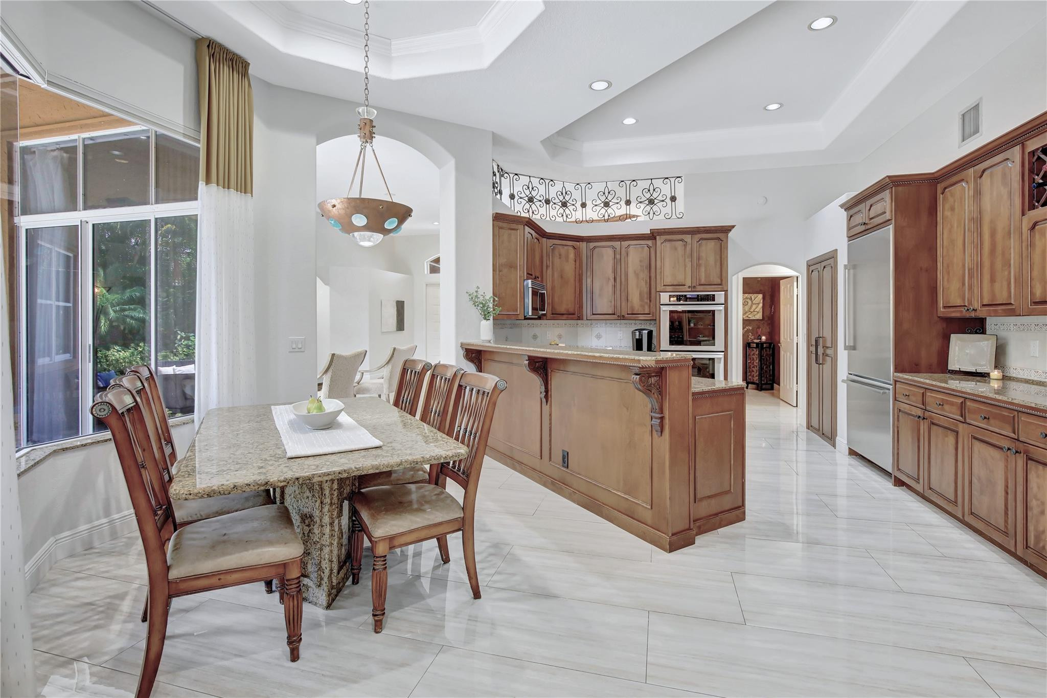 2529 Eagle Run Circle Fort Lauderdale, FL 33327 - Photo 5 of 74 a kitchen with stainless steel appliances kitchen island granite countertop a table chairs and a refrigerator