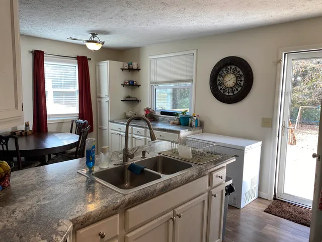 a kitchen with a sink a stove and a wooden floor