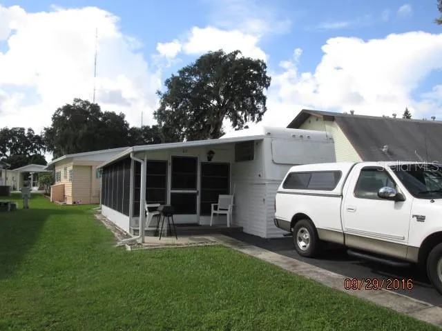 a white house covered with tall trees