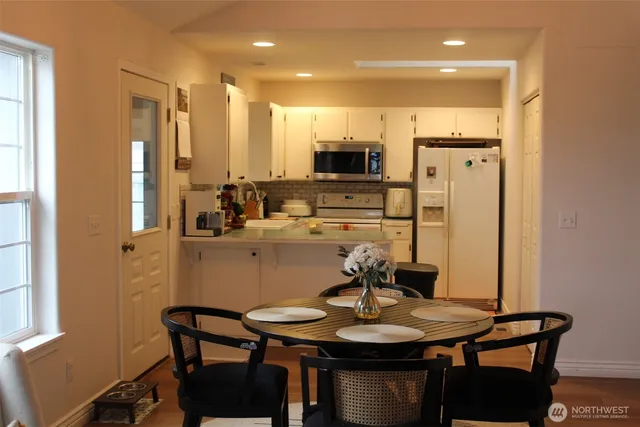 a kitchen with a table chairs and microwave