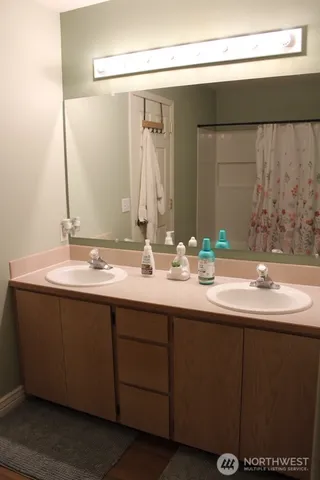 a bathroom with a double vanity sink and a mirror