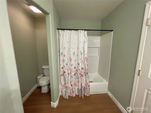 a bathroom with a toilet and shower curtain