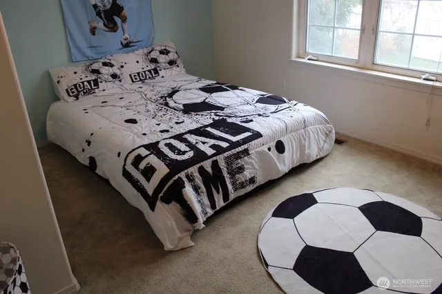 a bedroom with a bed that has a blanket and a window