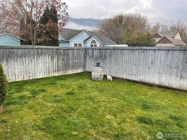 a view of a backyard with a garden and wooden fence
