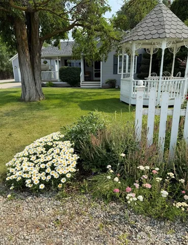 a front view of a house with a garden and trees