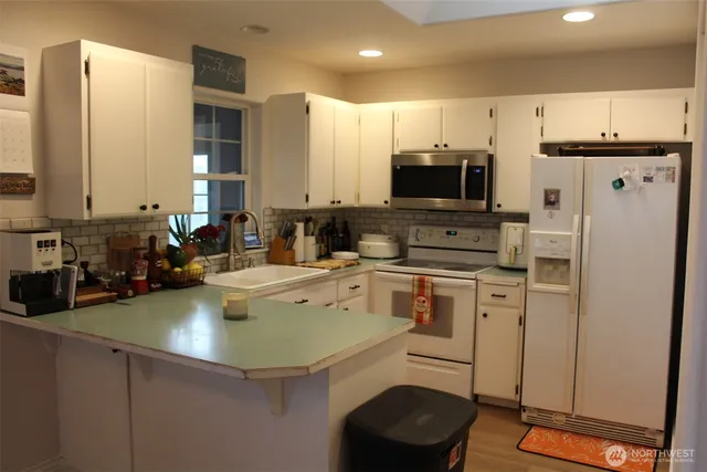 a kitchen with a sink a stove a refrigerator and cabinets