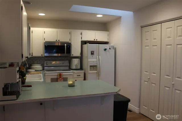 a kitchen with kitchen island a sink appliances and cabinets