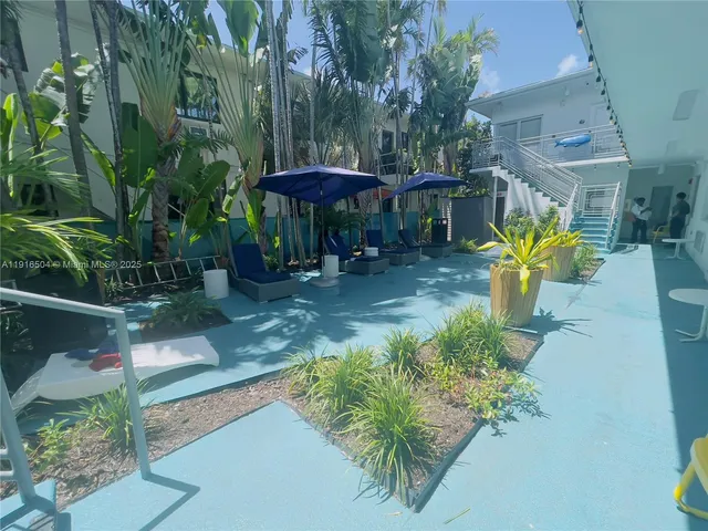 an aerial view of a house with table and chairs under an umbrella
