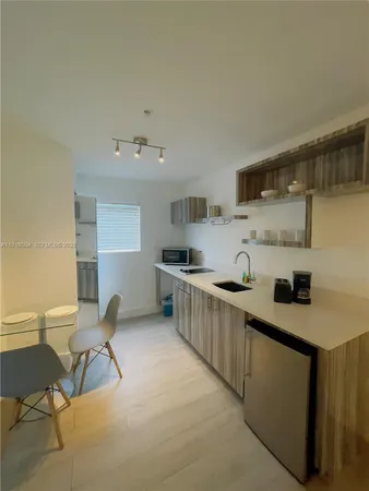 a kitchen with stainless steel appliances granite countertop a sink and a refrigerator