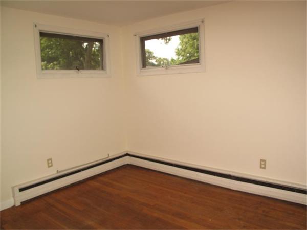 10 Stacy Street Randolph, MA 02368 - Photo 6 of 8 a view of an empty room with wooden floor and a window