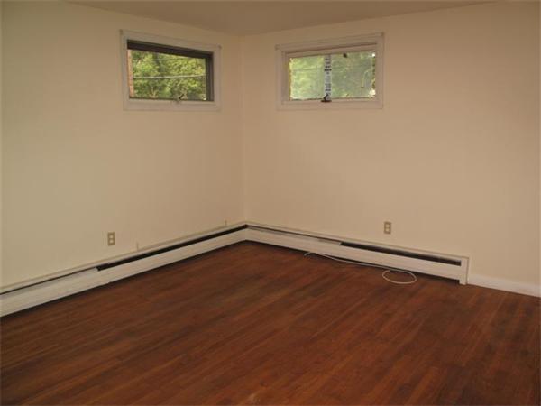 10 Stacy Street Randolph, MA 02368 - Photo 7 of 8 a view of an empty room with wooden floor and a window