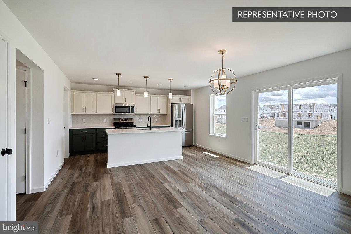 Black Cherry Plan At Hills Spring Grove, PA 17362 - Photo 21 of 42 a view of a kitchen with wooden floor and a large window