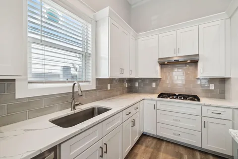 a kitchen with cabinets appliances a sink and a window