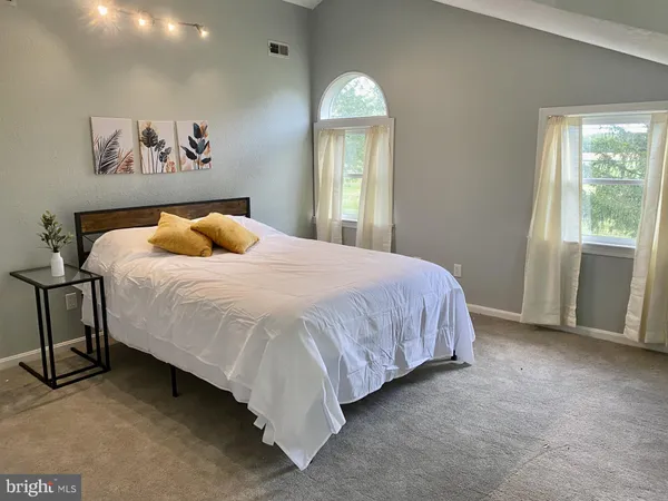 a bedroom with a bed and a painting on the wall