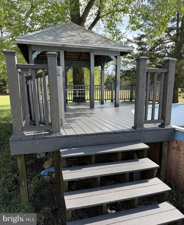 a view of backyard with wooden deck and outdoor seating