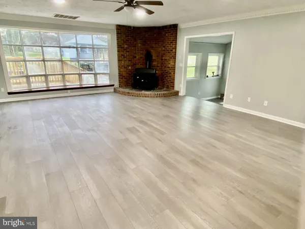 a view of an empty room with a fireplace and a window