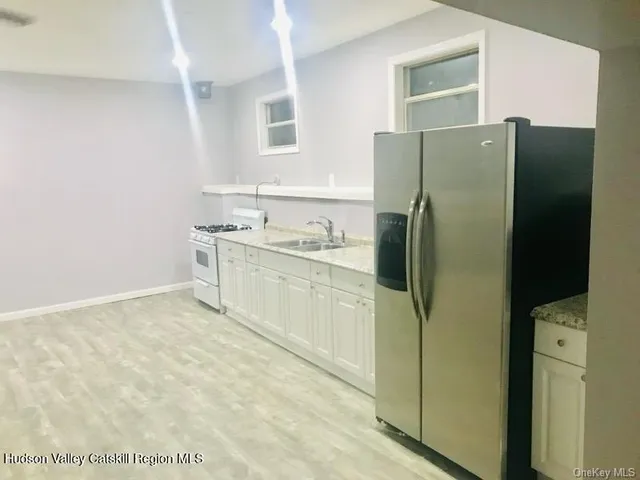 a kitchen with a refrigerator sink and cabinets