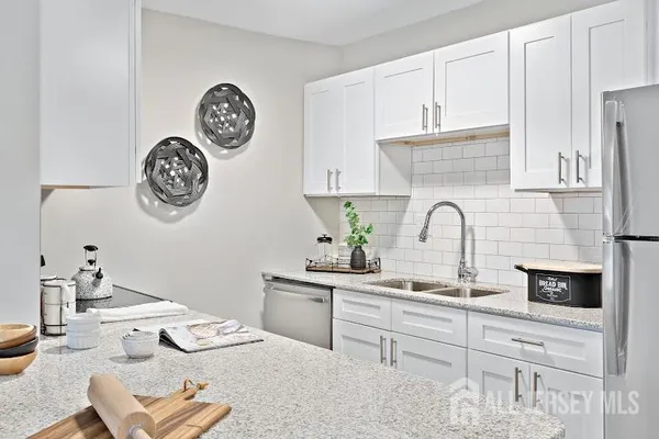 a kitchen with stainless steel appliances a white table and chair
