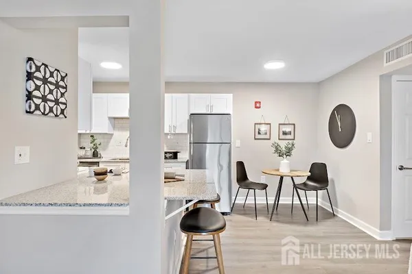 a kitchen with granite countertop a table chairs stove and cabinets