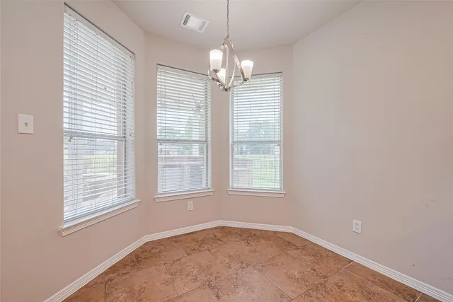 an empty room with windows and fireplace