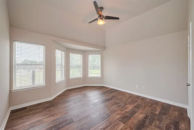 an empty room with a window and a fan