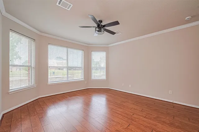a view of a big room with wooden floor and windows in a room