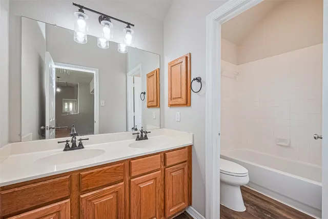 a bathroom with a granite countertop sink a mirror and a bathtub
