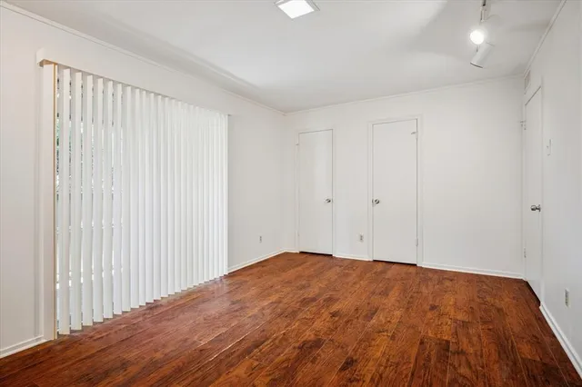 a view of empty room with wooden floor