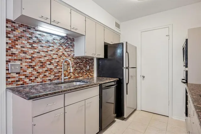 a kitchen with stainless steel appliances granite countertop a refrigerator and a sink
