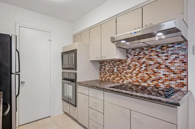 a kitchen with granite countertop a refrigerator and a stove