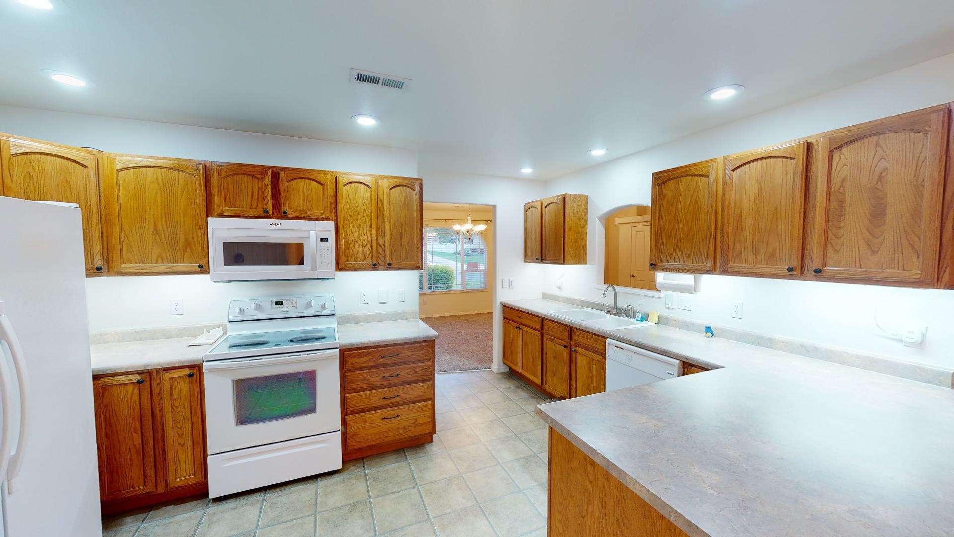 210 Limestone Circle Grand Junction, CO 81503 - Photo 4 of 32 a large kitchen with stainless steel appliances granite countertop a sink and cabinets with wooden floor