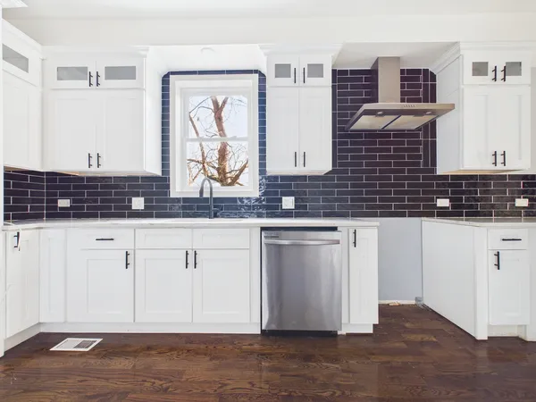 a kitchen with stainless steel appliances granite countertop a stove a sink and a microwave