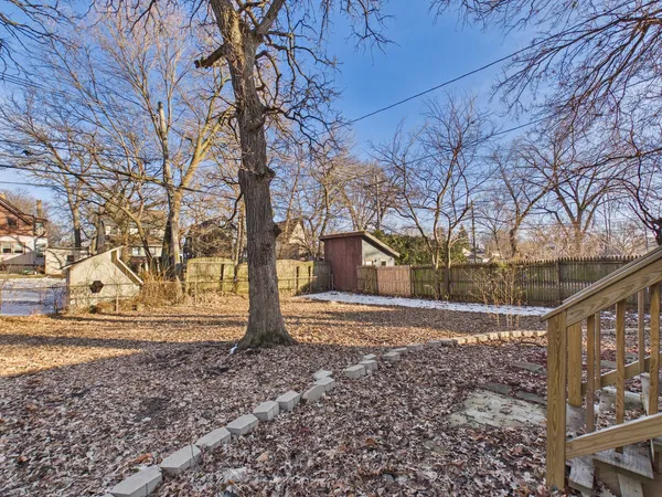 a view of a house with backyard and wooden fence