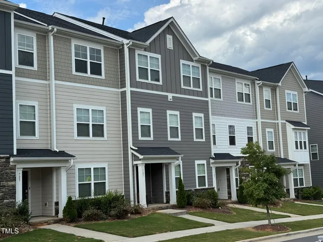 a front view of a residential apartment building with a yard