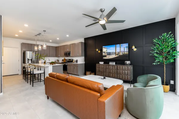 a living room with furniture kitchen view and a wooden floor
