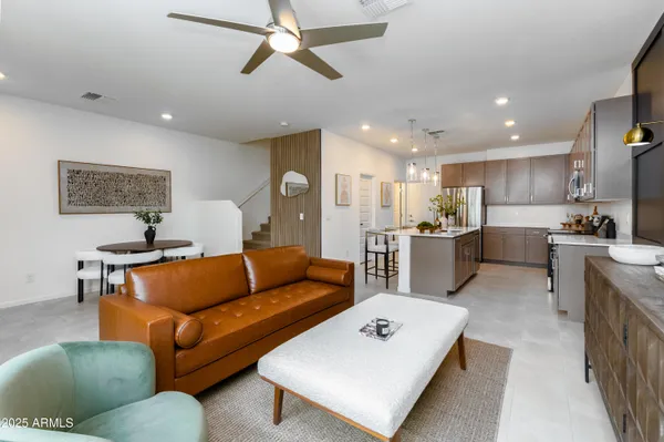 a kitchen with stainless steel appliances a sink dishwasher a stove top oven a refrigerator with wooden floor and cabinets